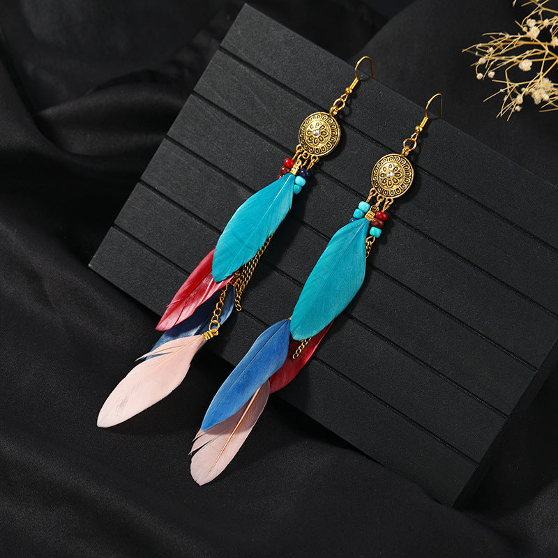 Closeup of blue feather tassel earrings