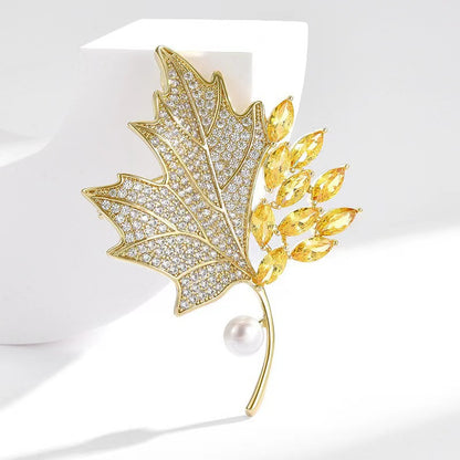 Golden maple leaf brooch with pearl accent